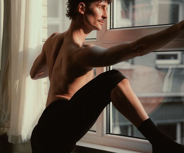 Silhouette of a man stretching against a sunrise, symbolizing energy.